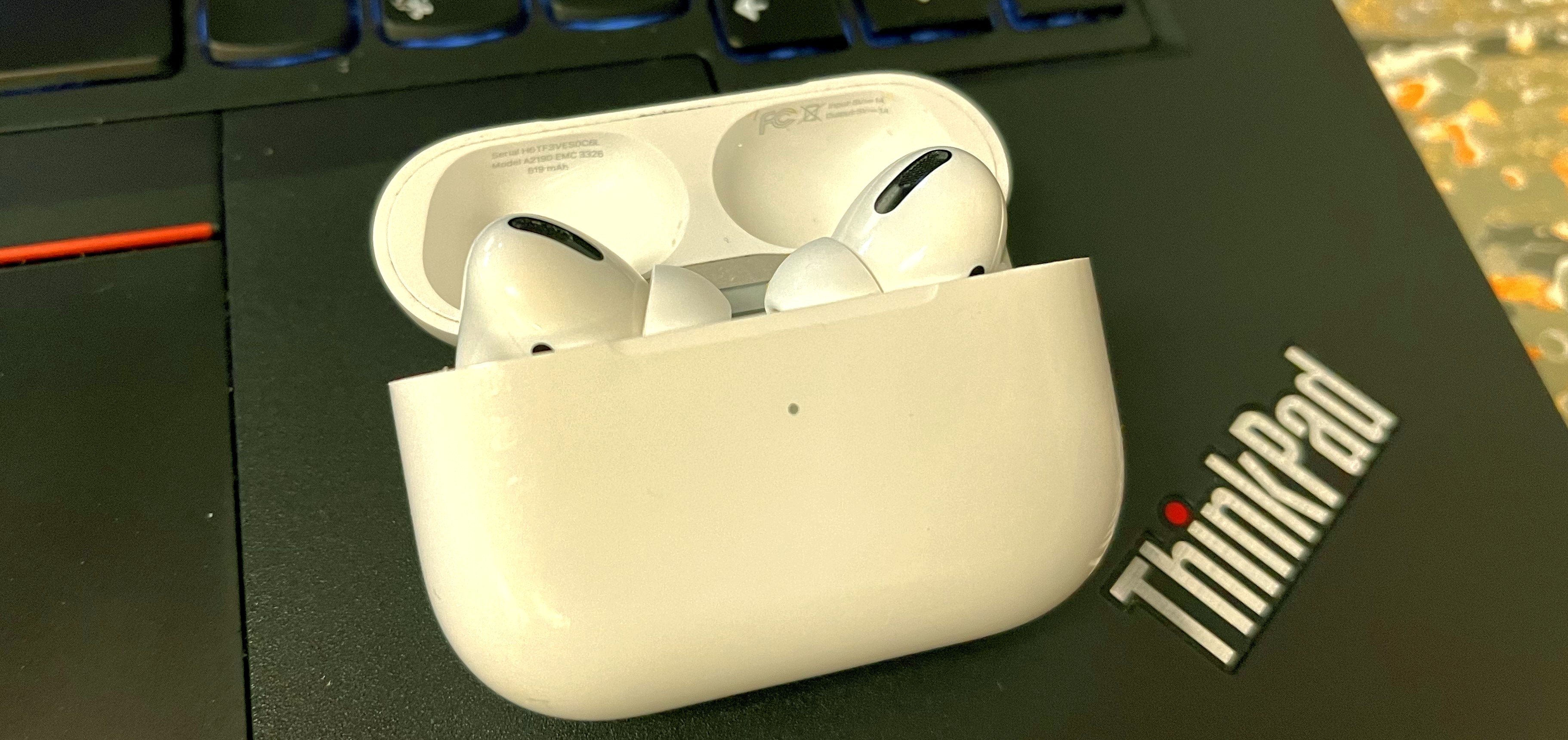 A set of AirPods sitting on a laptop
