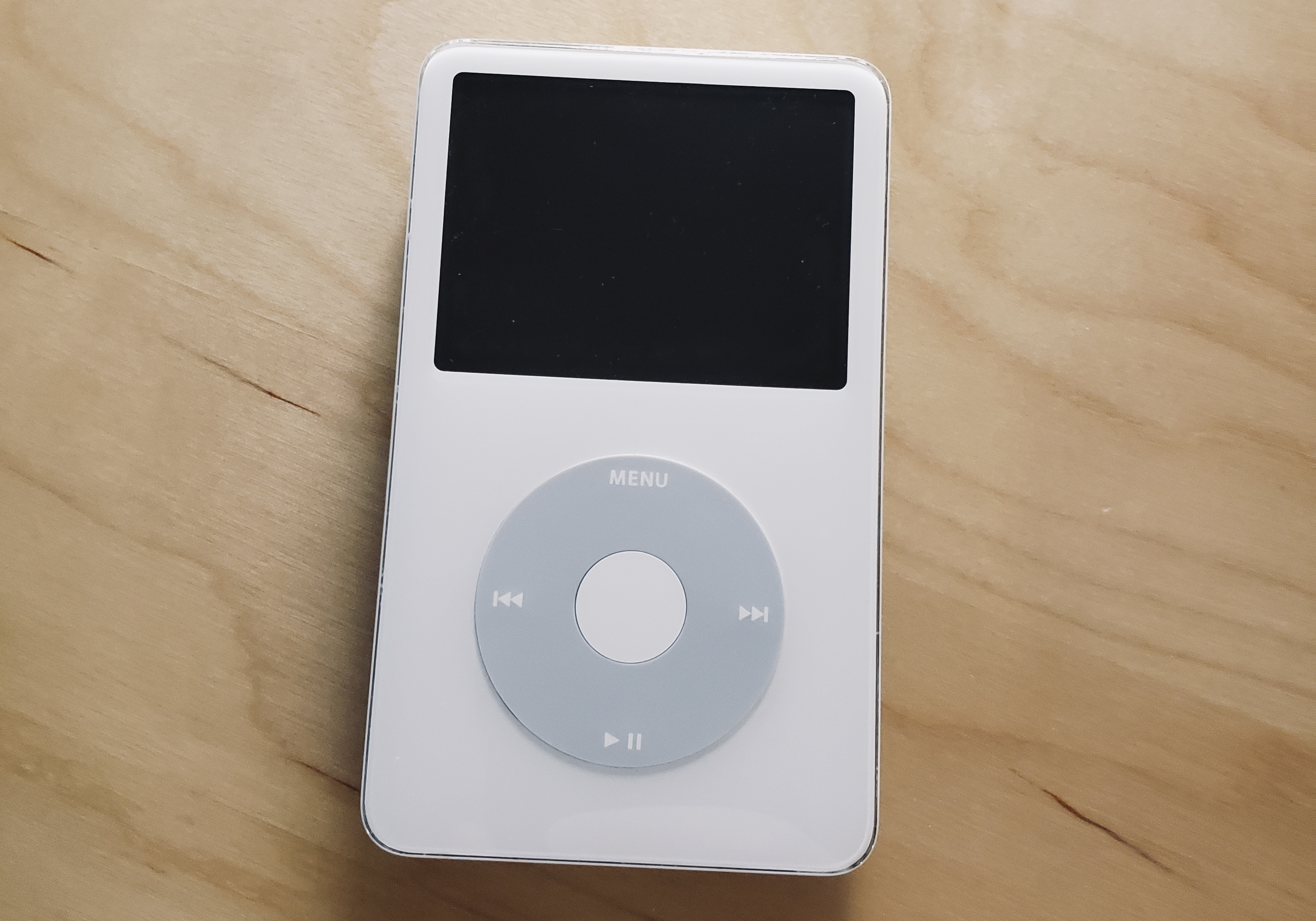 A white iPod on a wooden desk