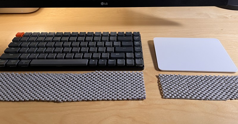 Shelf liner crookedly cut, in front of a keyboard and trackpad